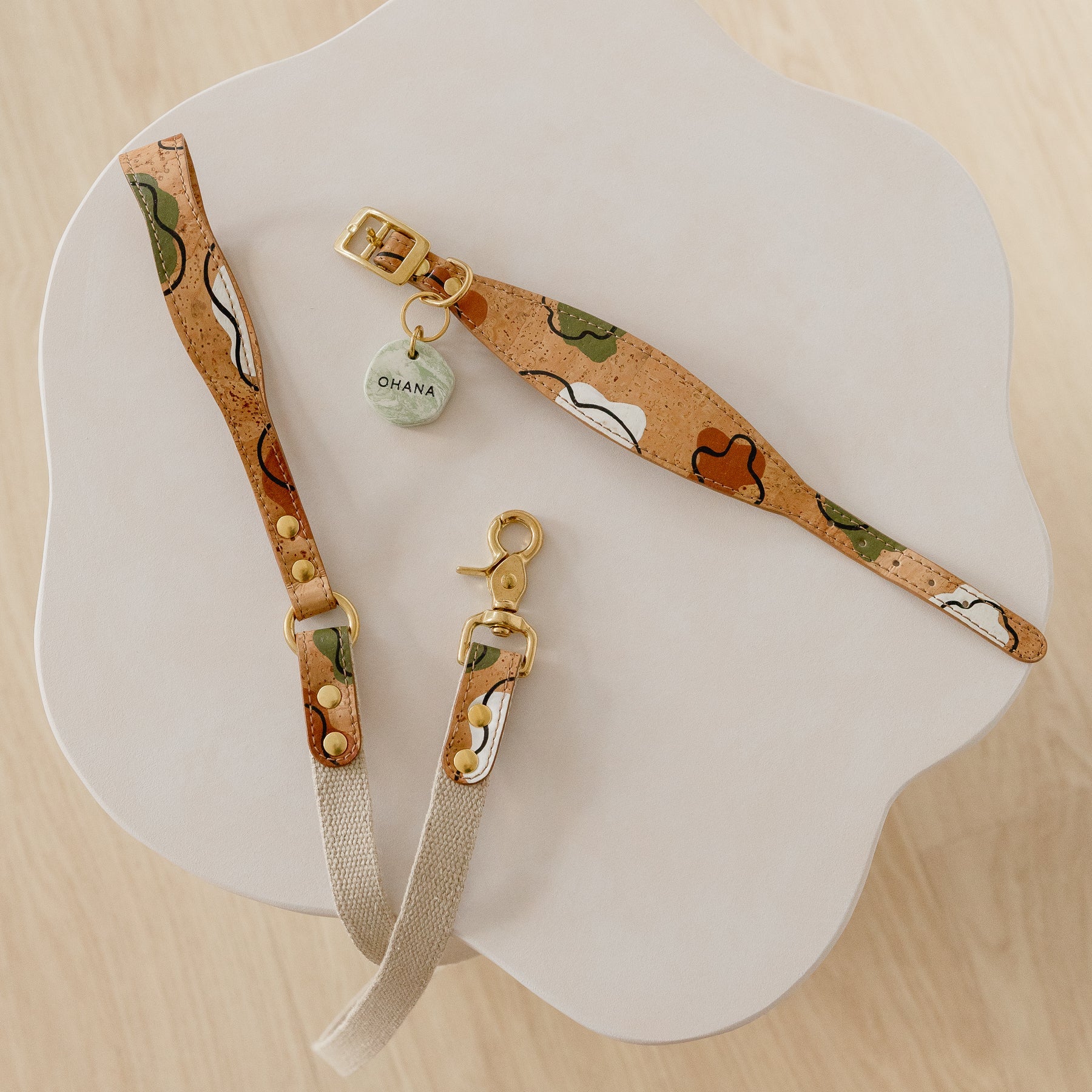 Cork leather dog accessories, including a hand-painted cork leather dog collar and leash set with brass details and a personalised dog ID tag