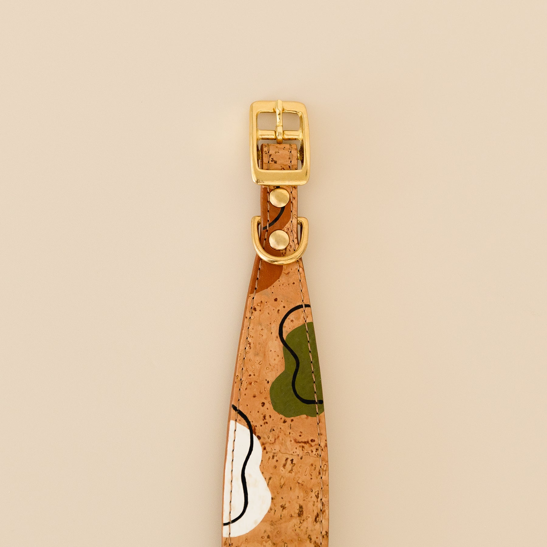 cork leather dog collar featuring hand painted edges, playful print and brass hardware, close-up