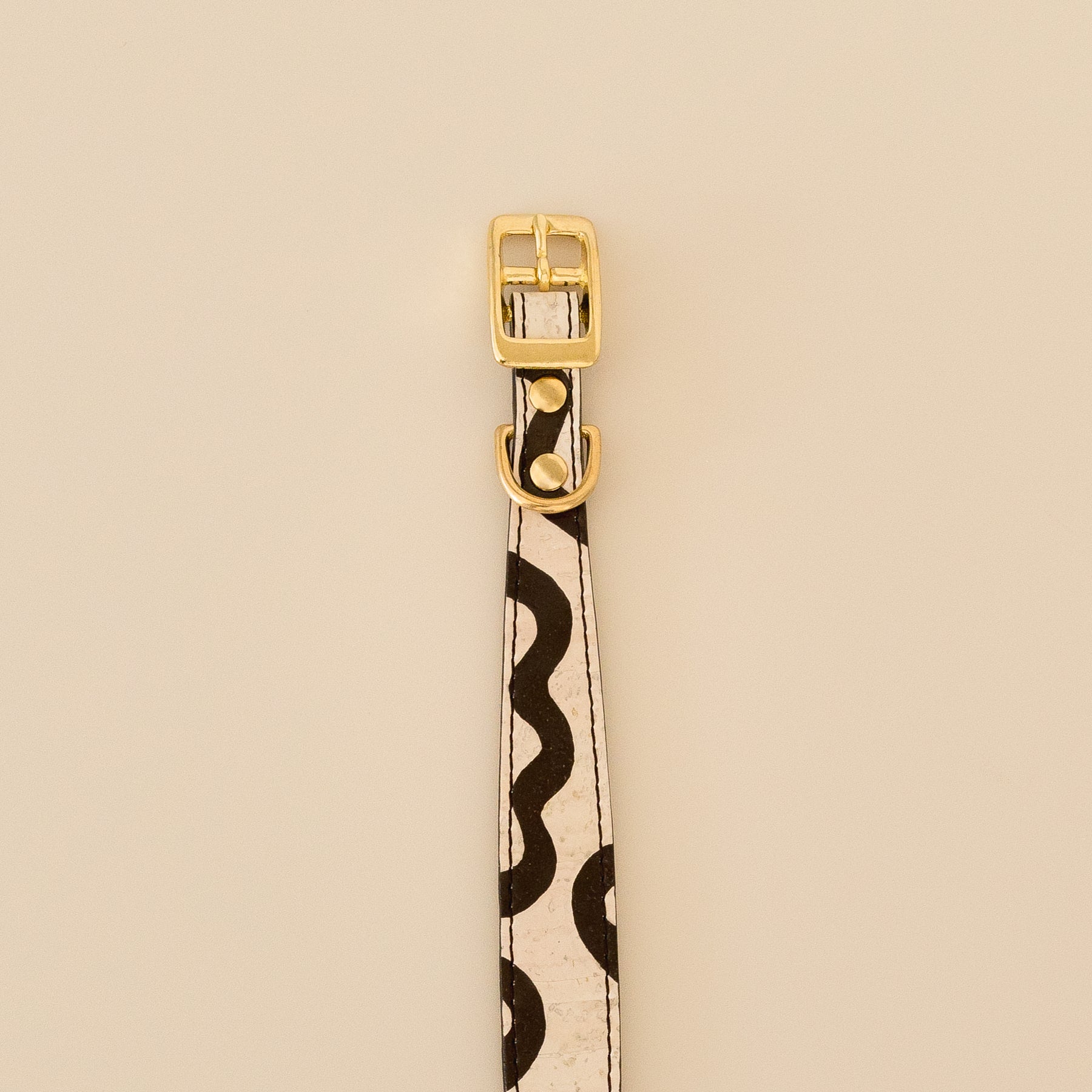 cork leather dog collar with hand painted edges, playful curves, and brass hardware, close-up