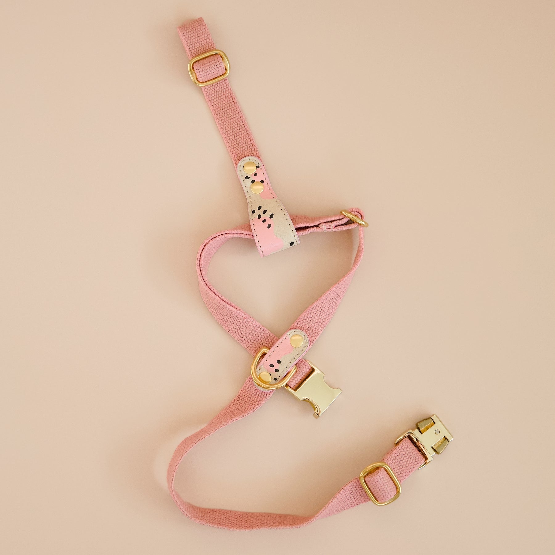 Pink vegan cork leather and organic hemp dog cross harness with brass hardware, hand-painted details, laid flat