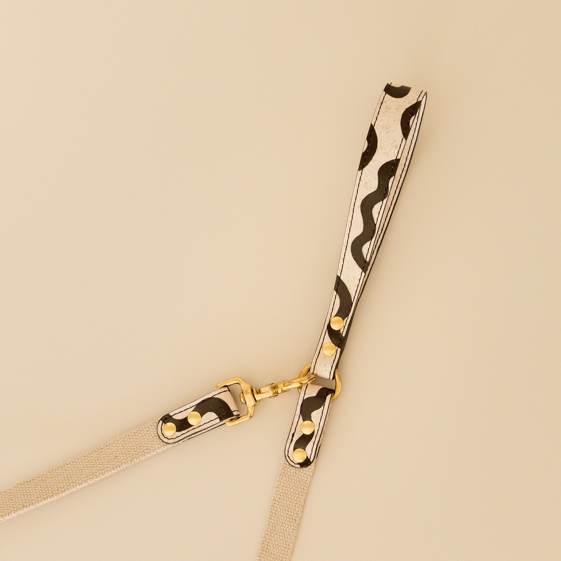 vegan cork leather dog lead with hand-painted bold curves and brass hardware, close-up