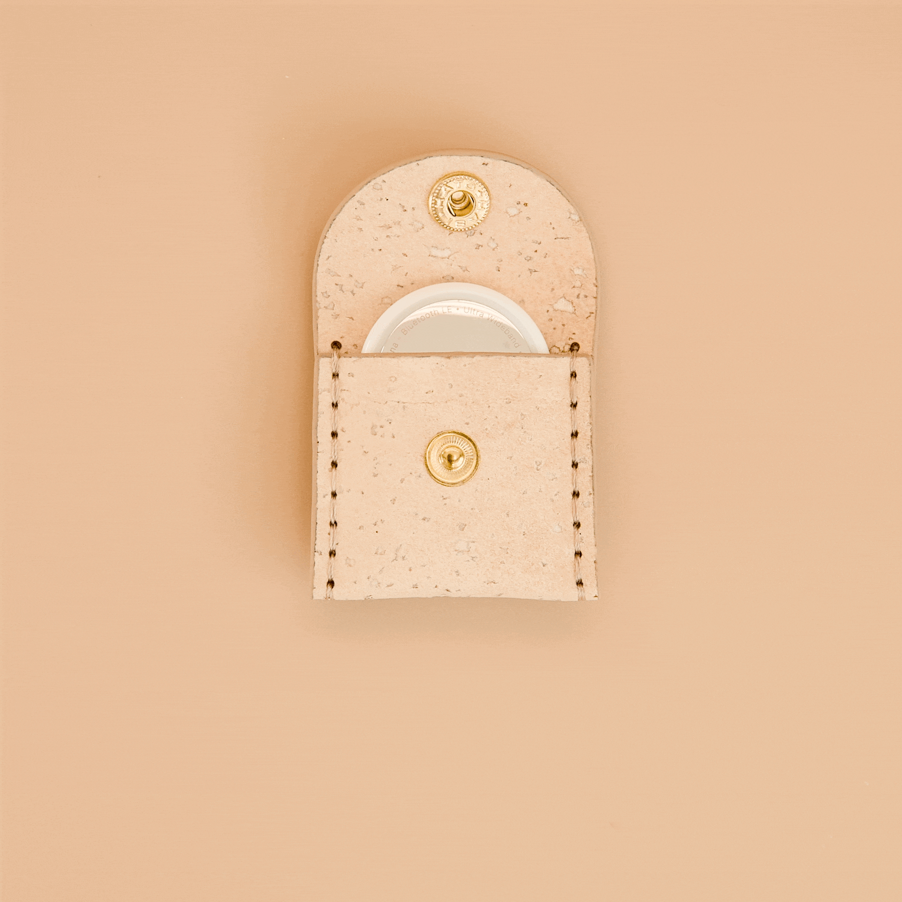 Cream beige cork dog airtag holder for dogs opening and closing with an Apple AirTag inside