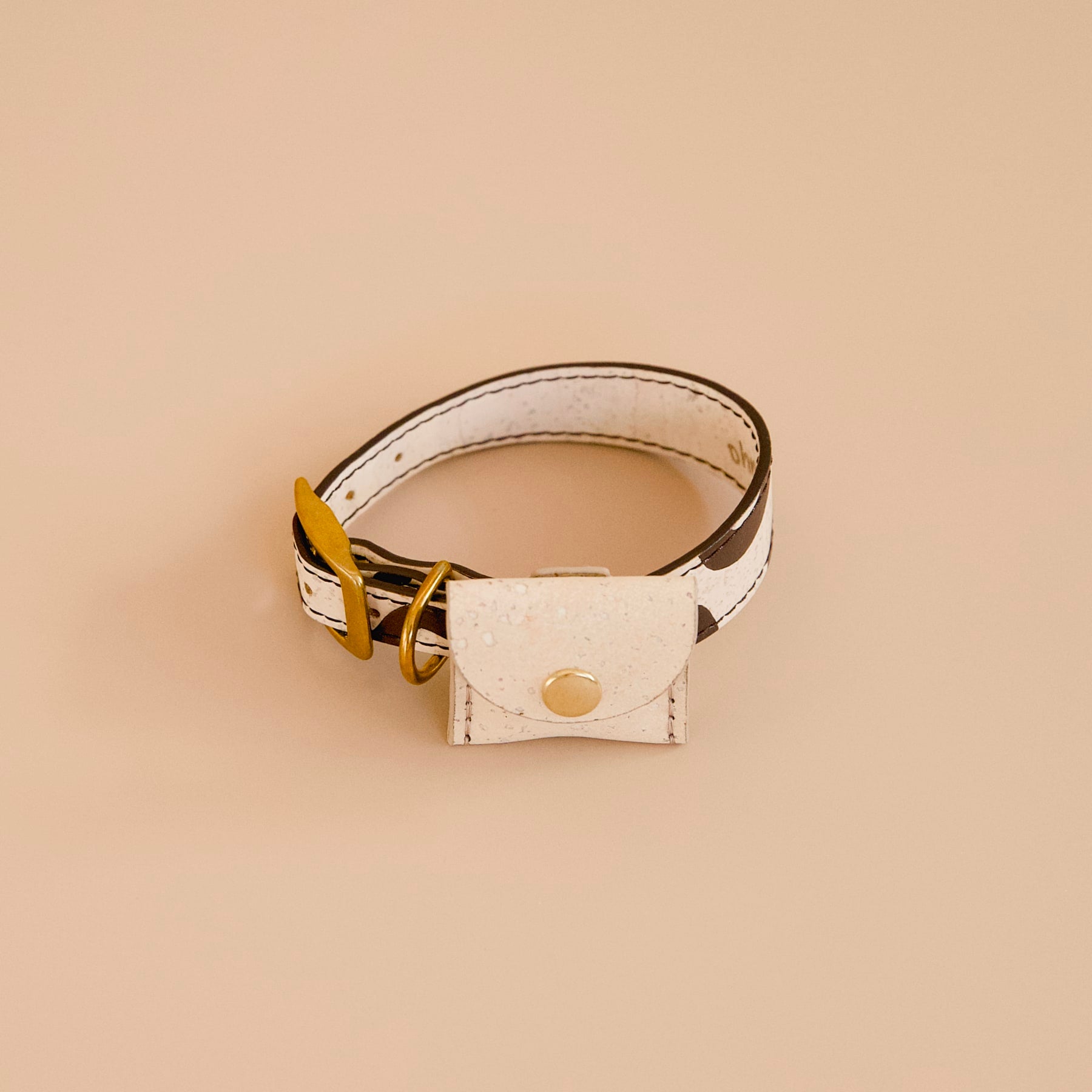 cork dog airtag holder on a dog collar in cream beige cork leather with brass details
