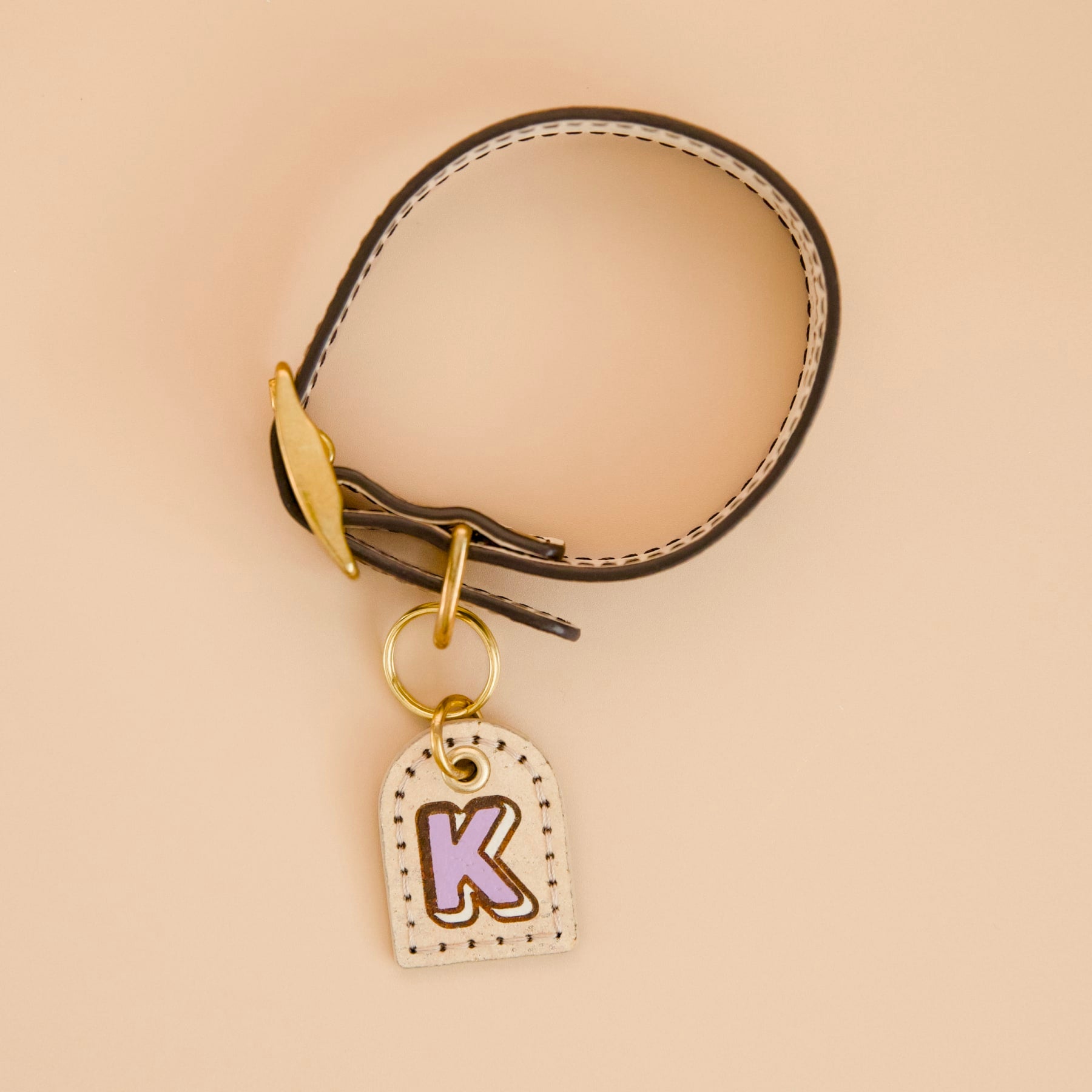 Cork leather dog ID tag with purple monogram, painted dark brown edges, Vegur design, attached to collar