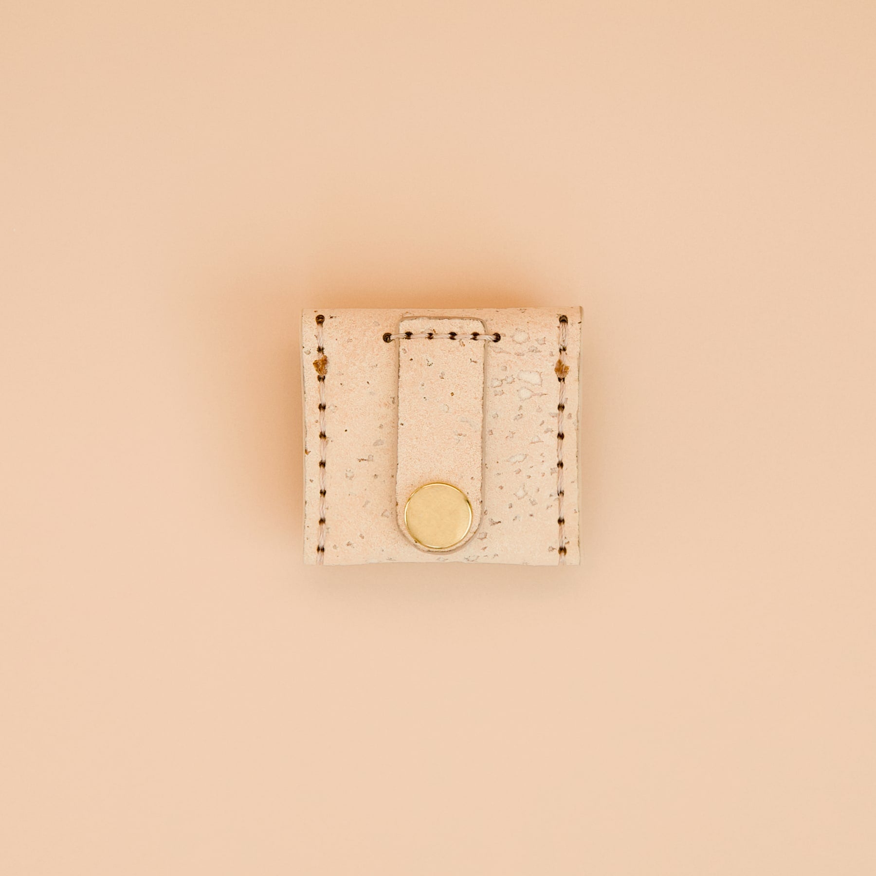 Cream beige cork dog airtag holder with brass details, back view