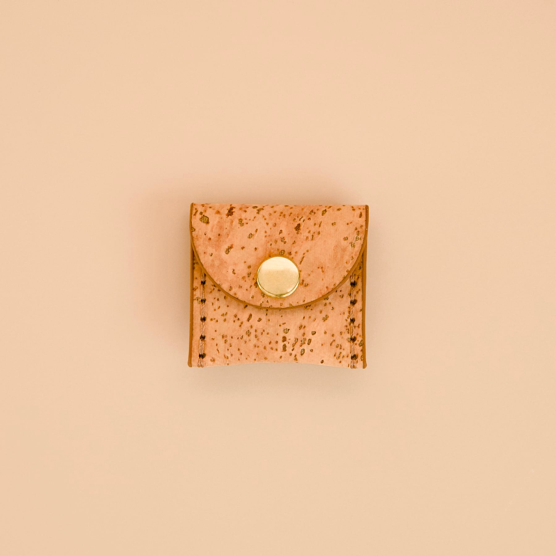 Mocha brown cork dog AirTag holder with brass details, front view