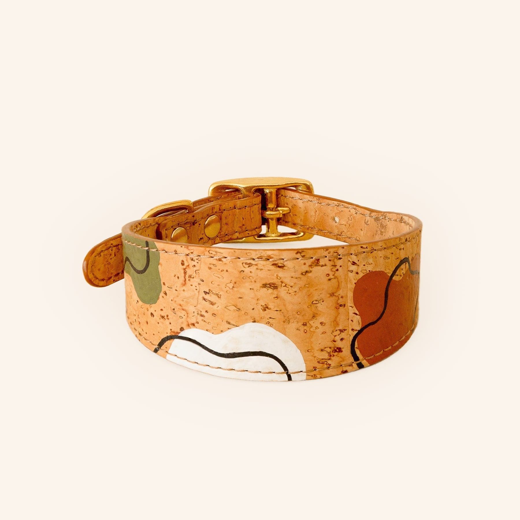 Brown cork dog collar with hand-painted pattern and brass hardware, front view.