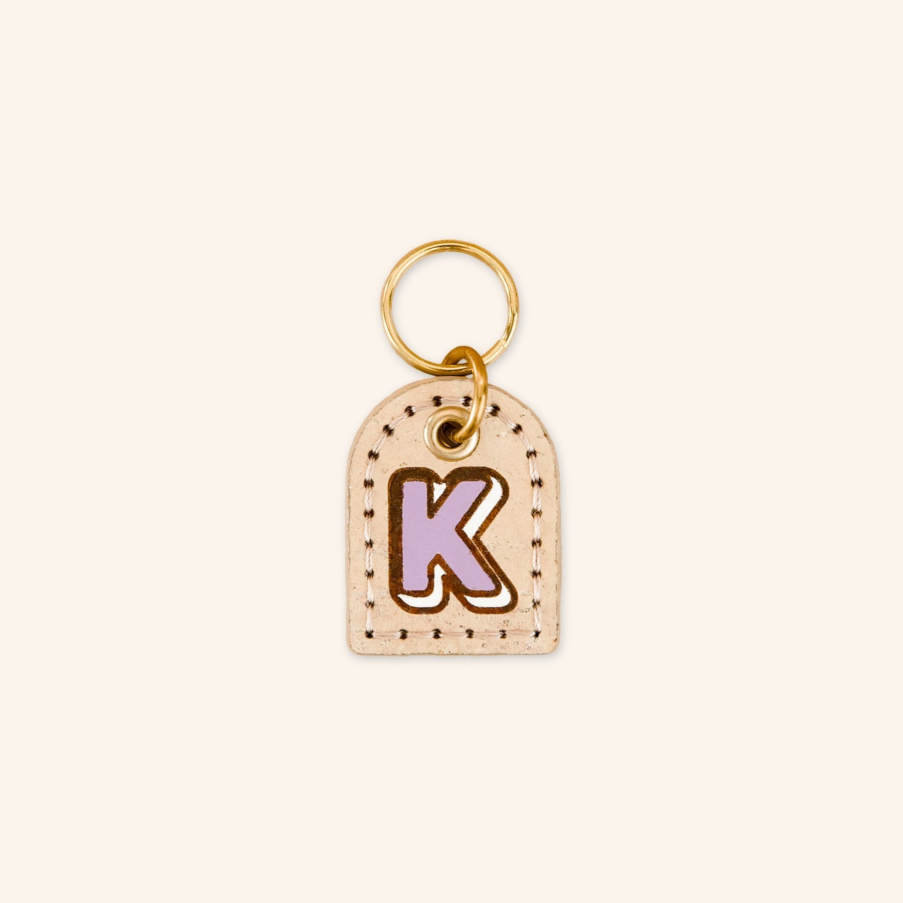 Dog tag with letter 'K' in purple on cream beige cork leather