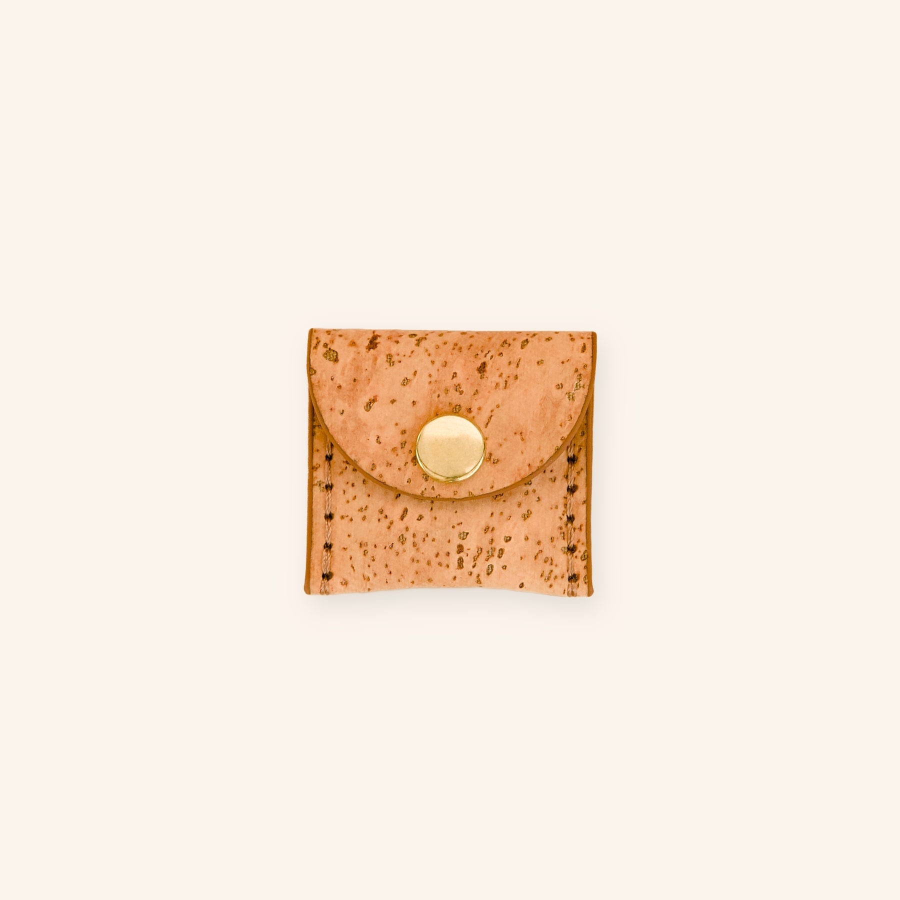 Dog airtag holder in mocha brown cork leather with a brass button, front view.